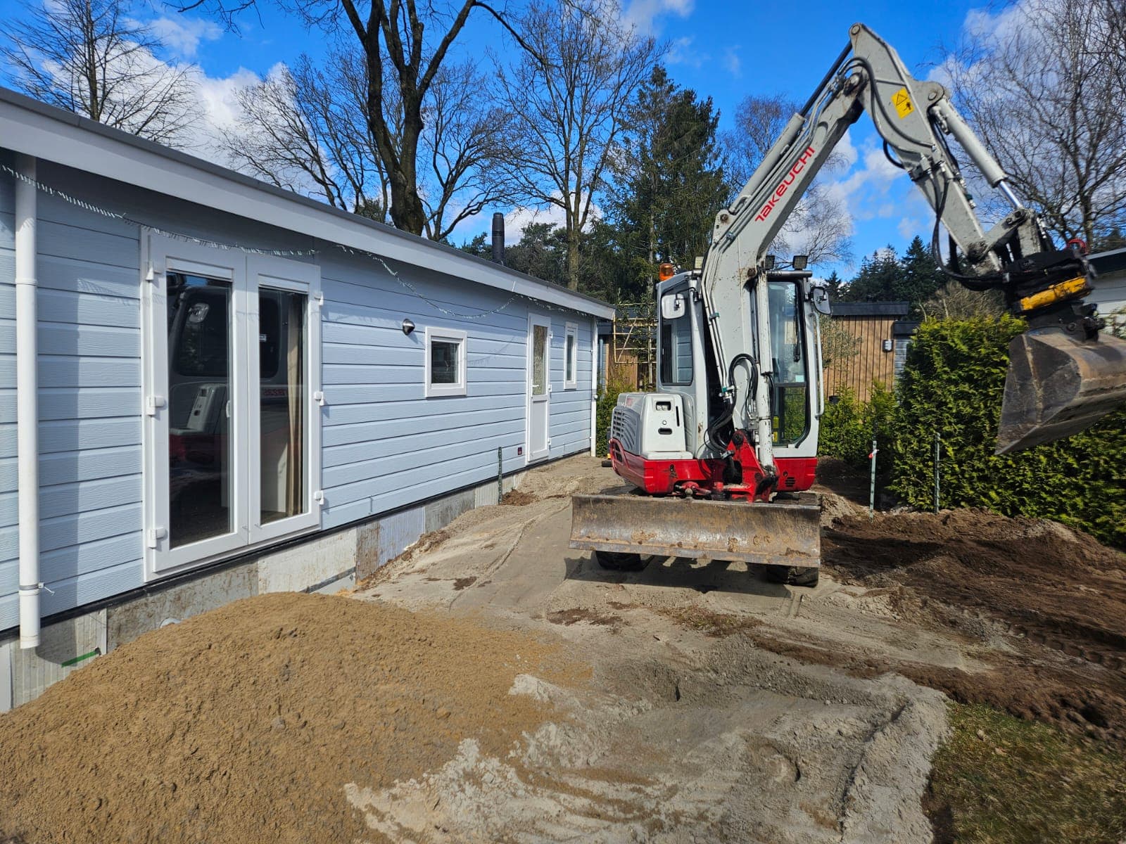 Takeuchi minikraan bij voorbereiding van een chaletplaats